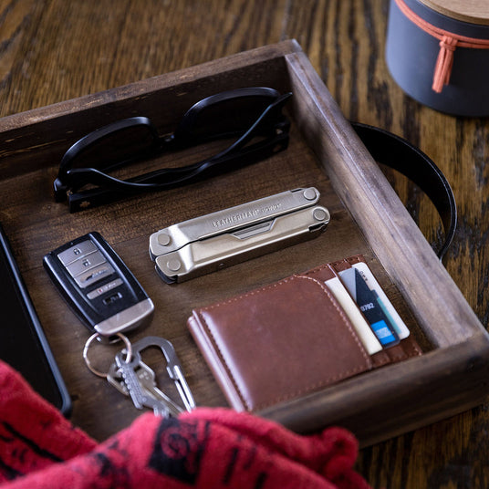 Translation missing: fr.A stainless steel Leatherman Bond closed on a tray next to a wallet, keys and sunglasses