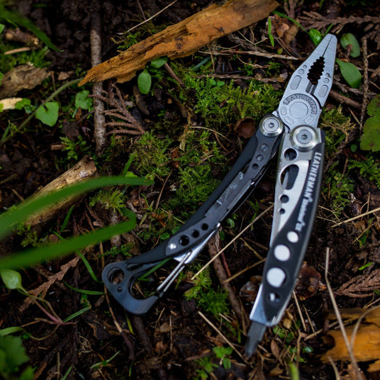 Translation missing: fr.Skeletool CX open laying on forest ground that is covered in moss and twigs