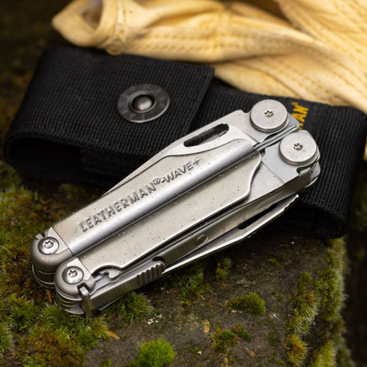 Translation missing: fr.Wave Plus closed leaning on a Black Nylon Sheath on a mossy rock next to a pair of gloves