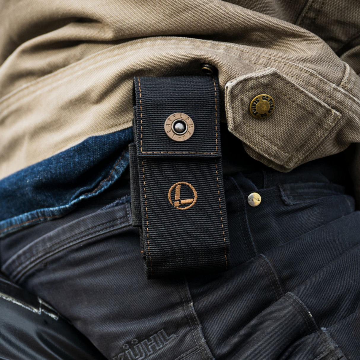 Translation missing: en.A man wearing a Leatherman Black Bronze Nylon Sheath positioned on his back, ready for carrying a Leatherman tool