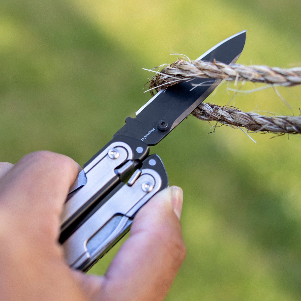 Translation missing: fr.Person using one hand to open a Black DLC and stainless steel Leatherman ARC® multitool