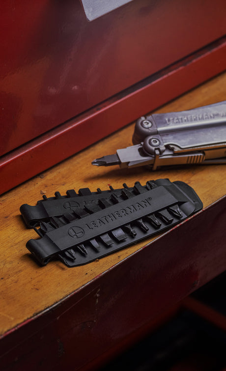 Translation missing: en.
Leatherman Bit Kit Set laying on a wooden surface alongside a Leatherman Stainless Steel multi-tool with a bit attached