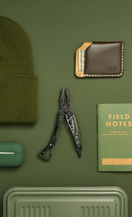 Translation missing: fr.A green Skeletool CX open showing pliers laying on a green background surrounded by green objects
