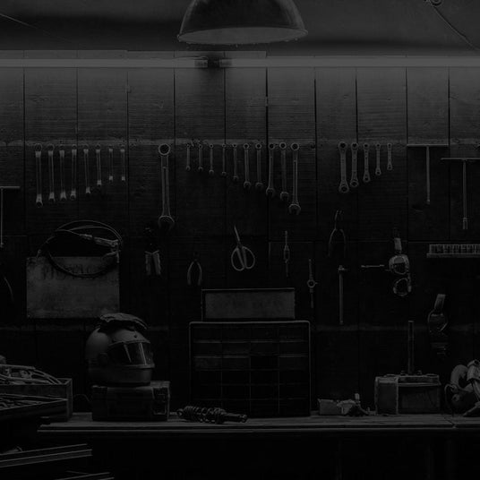 Translation missing: fr.A dimly lit workshop with various tools hanging on the wall, a workbench, and storage drawers