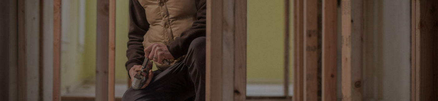 Translation missing: fr.A man in a jacket is actively engaged in work at a construction site, surrounded by tools and equipment