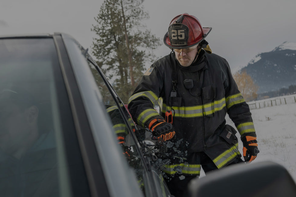 Translation missing: fr.A firefighter stands beside a car, wearing protective gear and looking ready for action