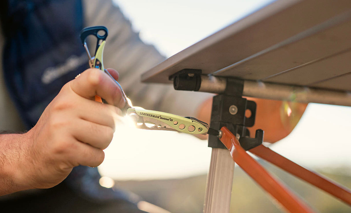 Translation missing: en.Hand using a Verdant Skeletool® CX multitool to tighten hardware on an outdoor table frame