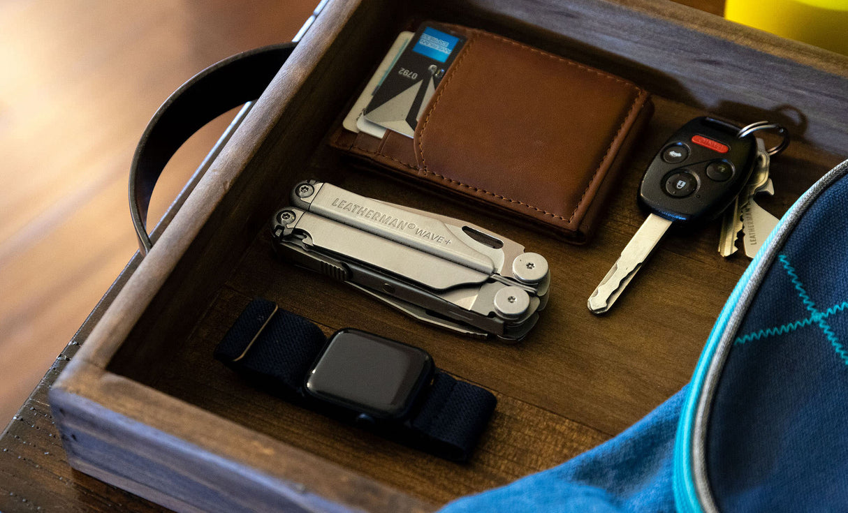 Translation missing: fr.Stainless Steel Leatherman Wave® Plus multi-tool in a wooden vanity with wallet, keys, and smartwatch