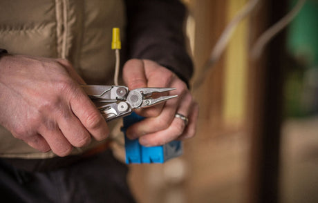 Man using leatherman wire crimper on electrical wires