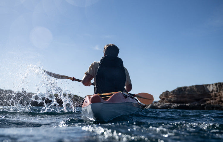 Man kayaking with a pack on