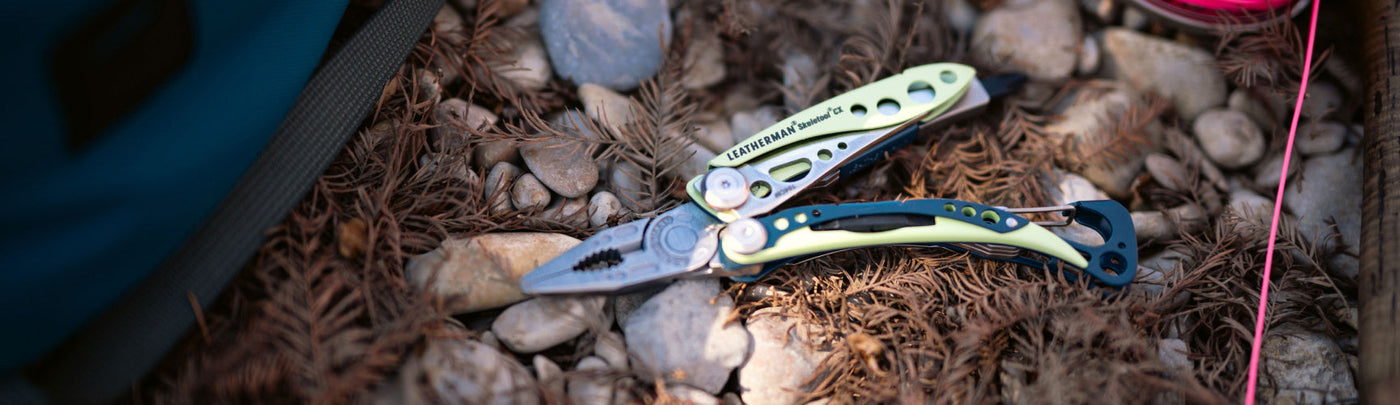 Skeletool CX open showing pliers on the ground outside next to a fishing line