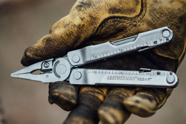 Gloved hand holding a leatherman Rebar with the pliers out