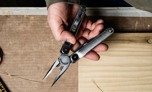 Translation missing: en.Man holding opened Leatherman Curl over table