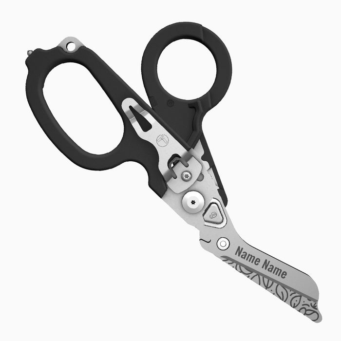 Translation missing: fr.A black-handled Leatherman Raptor Rescue tool with floral patterns engraved on the blade. The scissor blade includes the engraved placeholder “Name Name.”