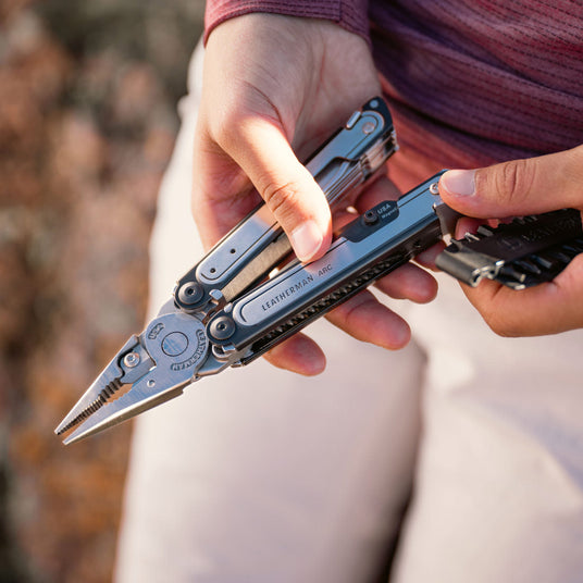 Person holding Leatherman Arc and bit kit.