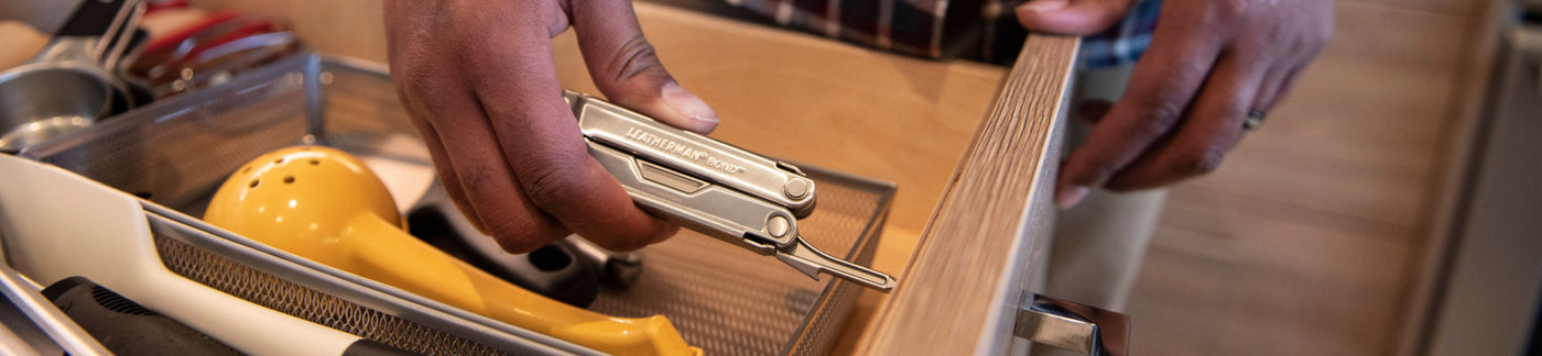 Person using Leatherman bond screwdriver to tighten handle screw on drawer.