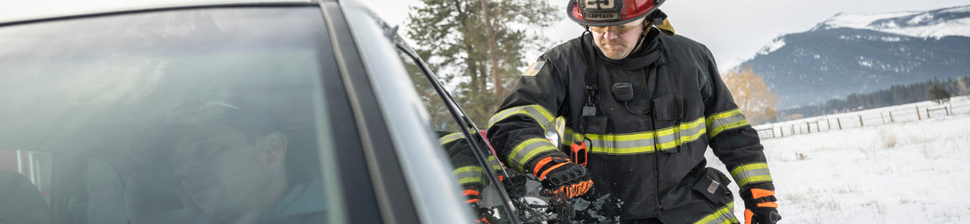 Firefighter assisting person stuck inside car.