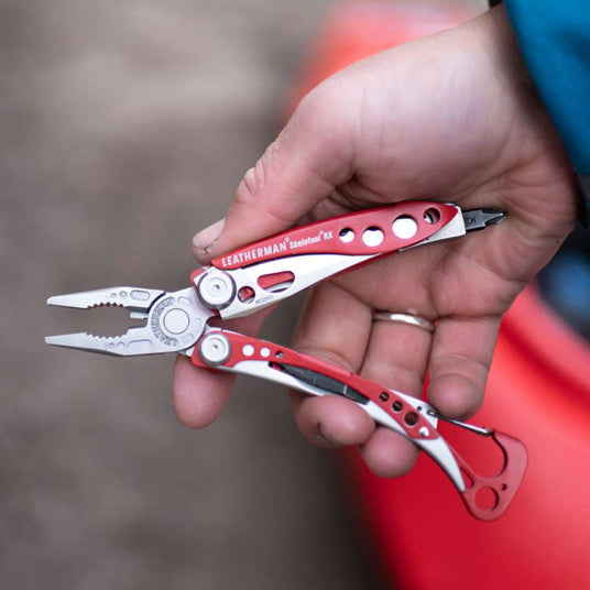 Person holding opened red Leatherman Skeletool RX.