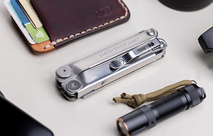 Translation missing: en.A collection of items including a wallet, a cell phone, Leatherman Curl and a flashlight arranged on a flat surface