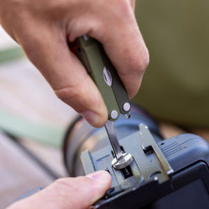 Translation missing: en.A person using the medium screwdriver on a Spruce Leatherman Micra® to tighten a camera mount