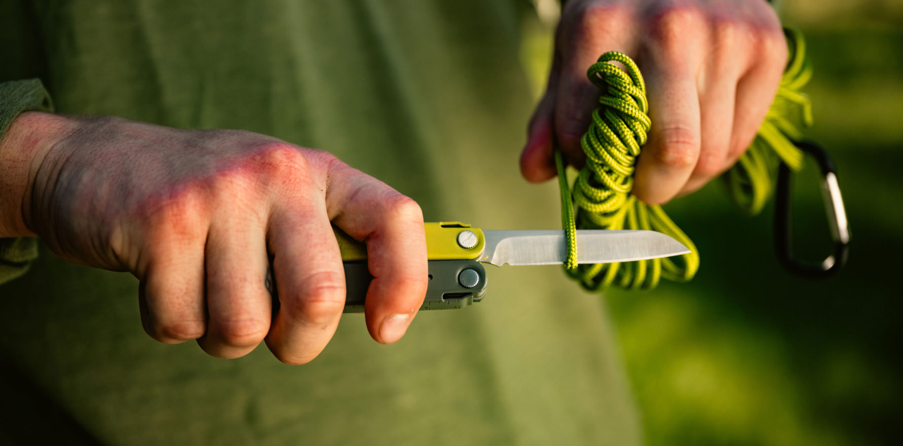 Man using Bond knife blade to cut a rope.