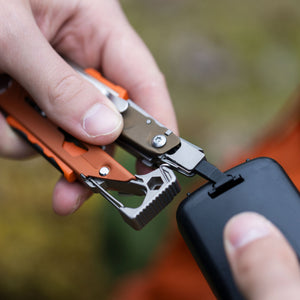 Translation missing: en.A person using the flat bit on a Tundrascape Leatherman Signal® to open a battery compartment